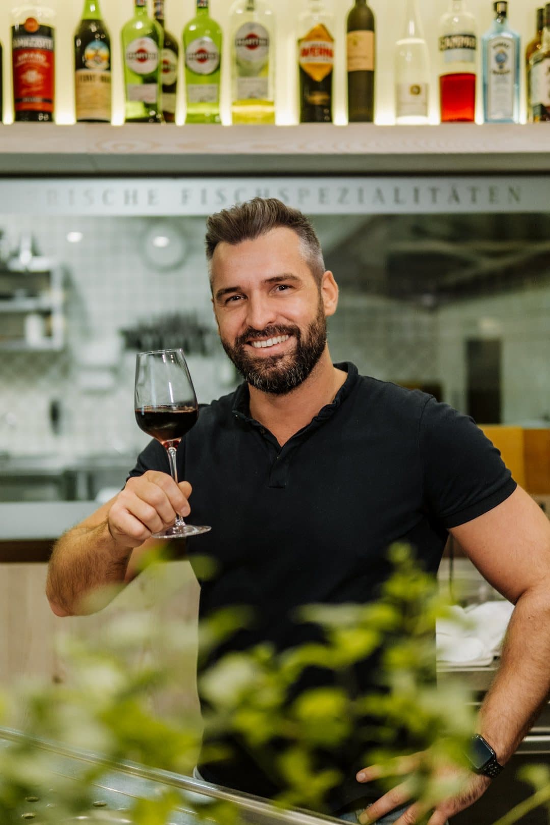 Andreas Kallioras, owner of Taverna Korfu, with a glass of red wine at the bar